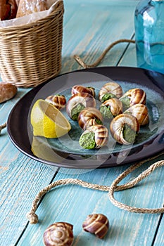 Bourguignonne snail with lemon. Blue wooden background