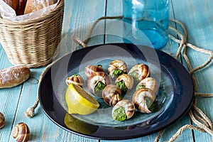 Bourguignonne snail with lemon. Blue wooden background