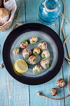 Bourguignonne snail with lemon. Blue wooden background