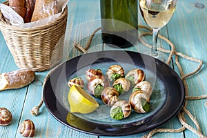 Bourguignonne snail with lemon. Blue wooden background