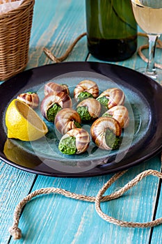 Bourguignonne snail with lemon. Blue wooden background