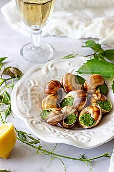 Bourguignonne snail with lemon. Marble background. French cuisine.