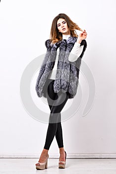 Boutiques selling fur. Woman makeup face wear fur vest white background. Luxury fur accessory clothes. Fashion trend