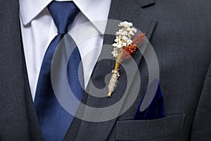 Boutonniere, tie, and handkerchief detail shot on the suit of a groom or groomsman photo