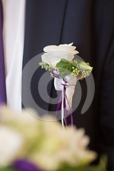 Boutonniere on trendy groom at wedding