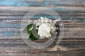 Boutonniere with white flowers on wooden background