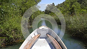 Bow Of Boat Advancing in Narrow River Surrounded By Reeds