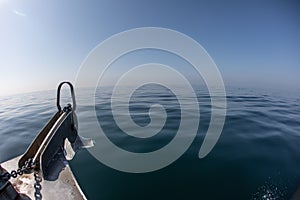 A bow of a boat on a calm ocean surface on a clear day