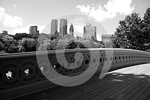 Bow bridge at Central Park and buildings of Manhattan in black and white style