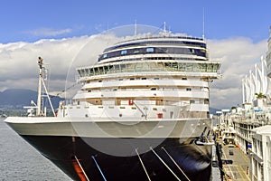 Bow of the cruise ship moored at the quay of a modern seaside ci