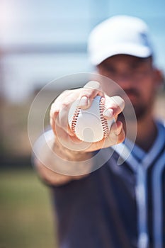 Bow down to the almighty baseball. a man holding a ball during a baseball match.