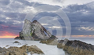 Bow-fidle Rock sunrise landscape on the coast of Scotland on cloudy morning