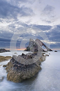 Bow-fidle Rock sunrise landscape on the coast of Scotland on cloudy morning