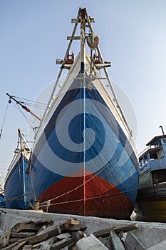 The bow of a huge old wooden boat in the port of the city of Jakarta