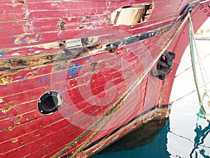 Bow and hull of Old abandoned wodden traditional fishing boat. Ancient Rusty Ship Board of old and colored boat wooden hull past