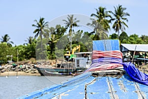 Bow of long-tail boat & view of boats & palm trees, Thailand