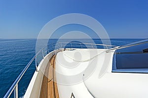 Bow of a luxury motor yacht cruising the blue sea.