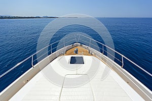 Bow of a luxury motor yacht cruising the blue sea.