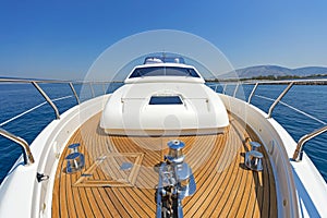 Bow of a luxury motor yacht cruising the blue sea.