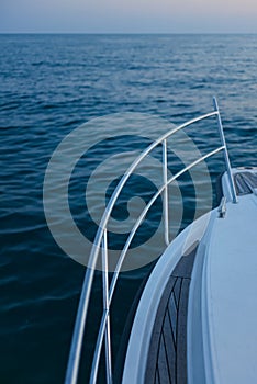 Bow motorboat yacht sailing on the sea at sunset
