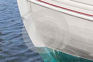 Bow of an old wooden boat, white green and red paint, copy space