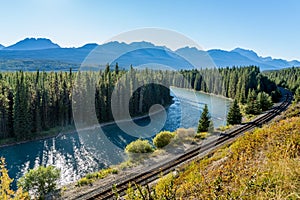 Bow River flows through forest and railway track. Storm Mountain in the background. Castle Cliff Viewpoint, Banff National Park