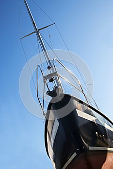 Bow of a sailing yacht from below against the blue sky, vertical