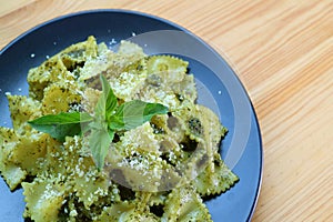 Bow-tie Pasta or Farfalle in Pesto Sauce Served on Wooden Table