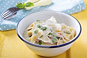 Bow ties pasta with ham and green peas