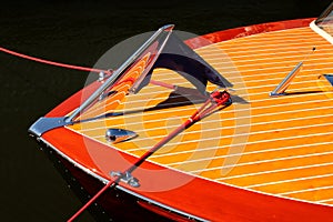 Bow of vintage wooden boat with crome reflecting wood stripes - red and yellow