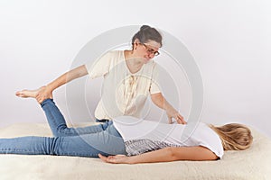 Bowen therapist giving a massage treatment to a young woman