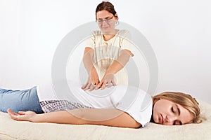 Bowen therapist giving treatment to a woman