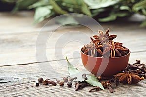 Bowl of anise stars. Gloves, laurel leaves. Ingredients for healthy cooking.