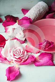 Bowl of aroma spa water with rose petals on towel, closeup