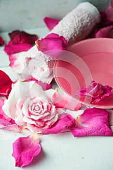 Bowl of aroma spa water with rose petals on towel, closeup