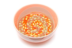 Bowl of baked beans isolated on a white background.