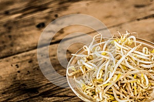 Bowl of bean sprouts on a rustic wooden table