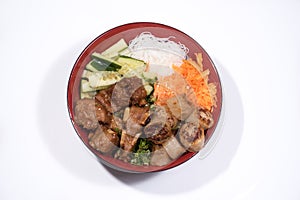 Bowl of beef Bo bun with salad, pork ribs, fresh herbs