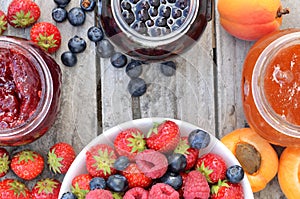 Bowl with berries fruit and jams - strawberry, apricot, blueberry