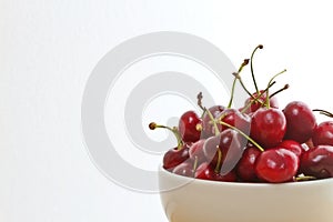 Bowl of bing cherries against white background photo