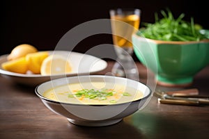 bowl of bisque with side of lemon and chives