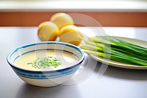 bowl of bisque with side of lemon and chives