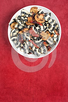 Bowl of Black and White Pasta on Rust Suede Background, Vertical