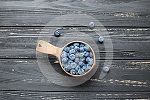 Bowl with blueberries on center of wooden table