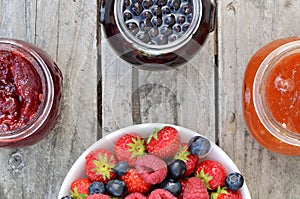 Bowl with blueberries, strawberries, raspberries and jams