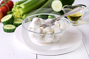 Bowl of Bocconcini Mozzarella Fresh Tomatoes Cucumber Celery Olive Oil Italian Salad Healthy Food White Background