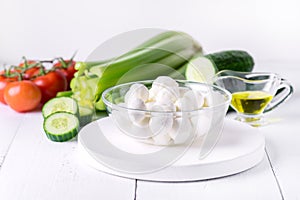 Bowl of Bocconcini Mozzarella Fresh Tomatoes Cucumber Celery Olive Oil Italian Salad Healthy Food White Background