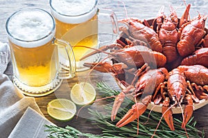 Bowl of boiled crayfish with two mugs of beer