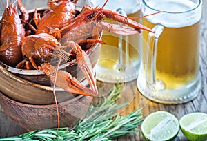 Bowl of boiled crayfish with two mugs of beer