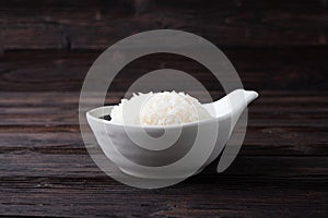 Bowl of boiled rice served on wooden table